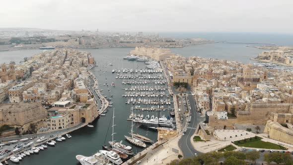 Aerial footage of the harbors of 'Three Cities of Malta' along the coast of the Mediterranean Ocean