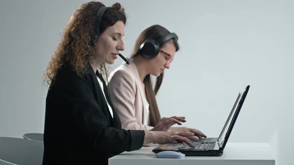 Customer Support Agent or Call Center with Headset Works on Desktop Computer While Supporting the