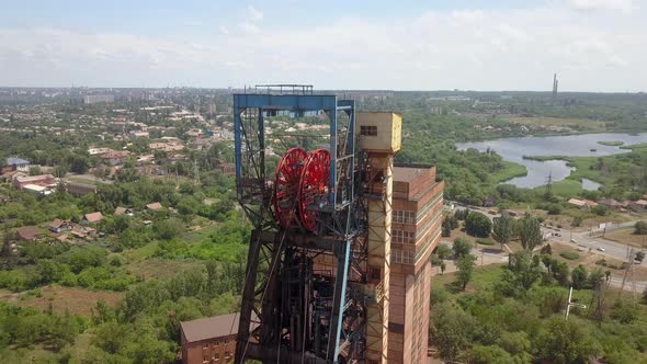 Headframe. Iron ore mining in the city center. Red mine in the city.