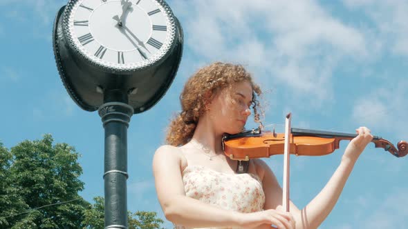 young curly blond woman the violinist: Musician playing violin