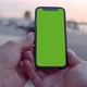 Pov Bokeh Shot of Man Hands Holding Modern Black Mobile Phone with Blank Green Screen - VideoHive Item for Sale