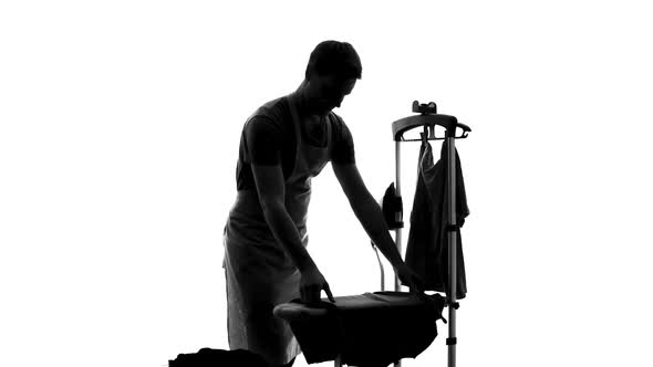 Smiling Male Householder Ironing Clothes on Board, Sharing of Housework Duties