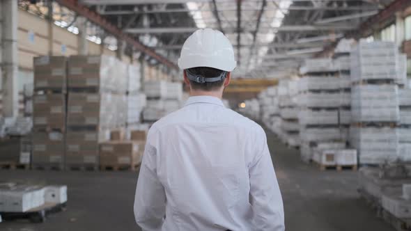 Follow footage of employees male warehouse worker engineer in hard hat working.