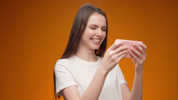 Young Woman Playing Games on Her Smartphone in Studio