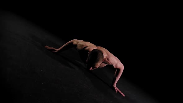 Young Pumped Man Training His Hands in the Dark Arena