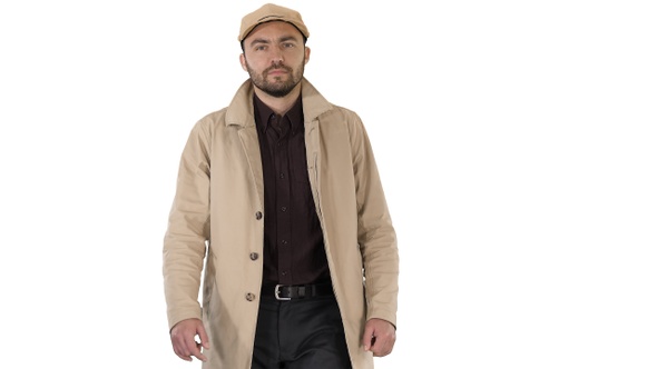 Fashionable man with dark beard in trench coat walking