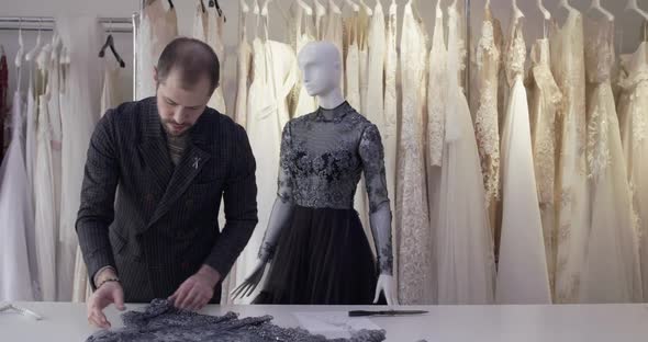 The Tailor Spreads the Fabric on a Work Surface in Atelier