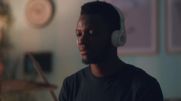 African American Guy Playing Drums in Dark Room