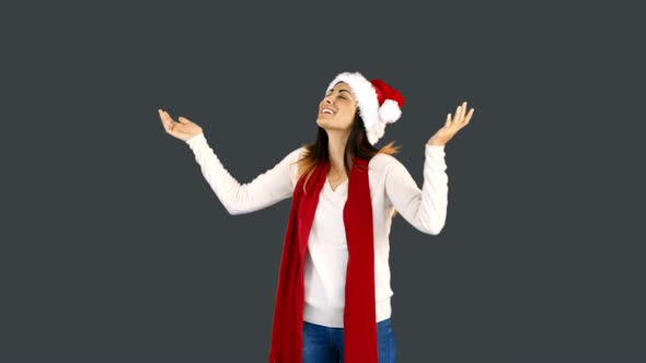 Woman in santa hat and warm clothing looking upwards