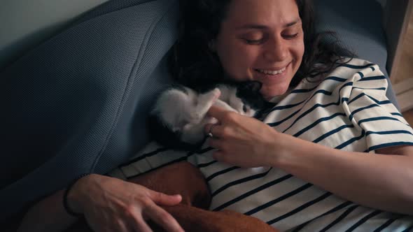 A Young Woman Playing with Her Small Kitten