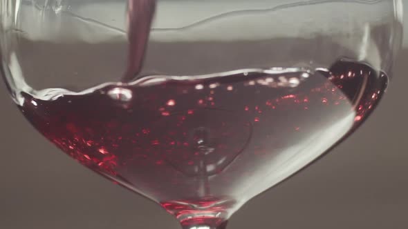 Close up Pinot Noir poured into glass slowly swirling around, Slow motion