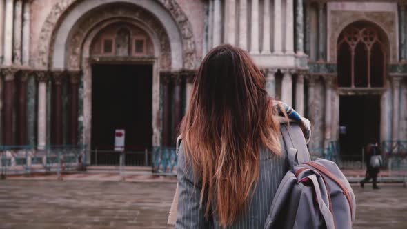 Woman Tourist with Backpack Walking To Old Antique Building in Venice Italy