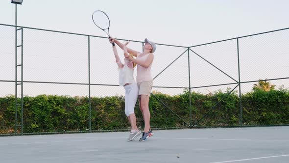 Mom Is Trying To Teach To Play Tennis. Family Activities