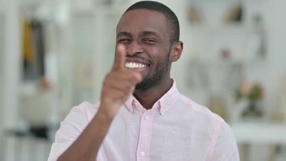 Portrait of Smiling African Man Pointing with Finger