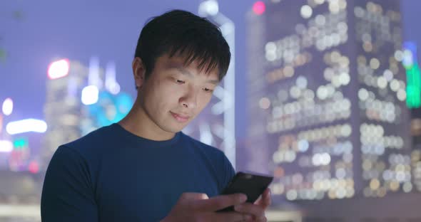 Man use of mobile phone in Hong Kong city at night