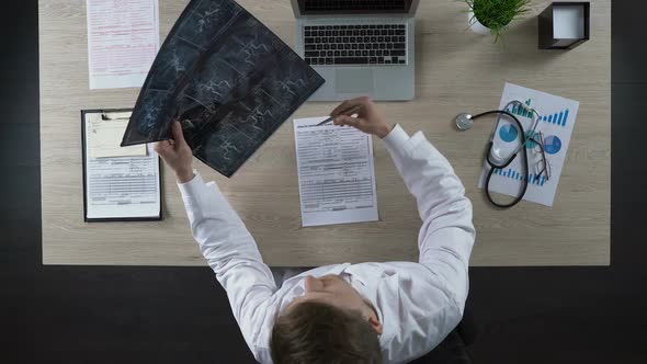 Consulting Physician Looking at Scan of Blood Vessels Pointing to Problem Places