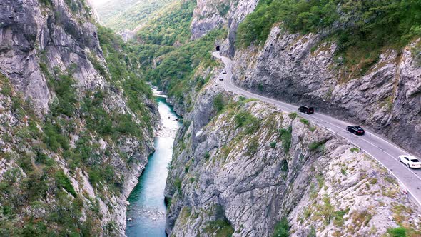 Canyon and road cut in its rocky wall, with stream at the bottom of deep ravine - Montenegro nature