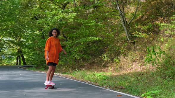 Sporty Girl Spending Free Time in the Park and Skateboarding