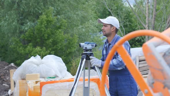 Male Construction Worker On A Construction Site With A Laser