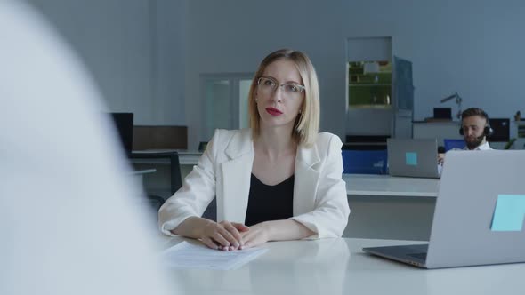 Beautiful Woman Speaks with Her Coworker in an Office