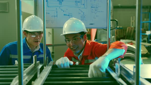 Male Asian engineer professional  having a discussion standing by the agv machine