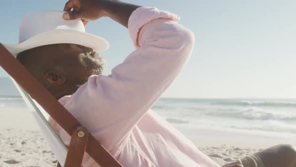 Senior african american man lying on sunbed on sunny beach