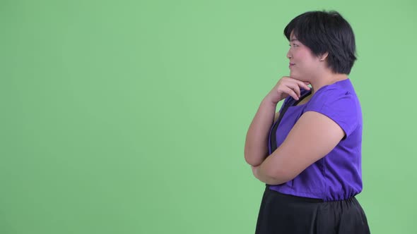 Profile View of Happy Young Overweight Asian Woman Thinking