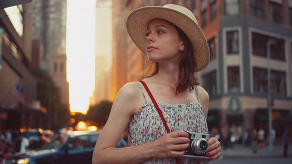 Beautiful girl with a retro camera in Manhattan