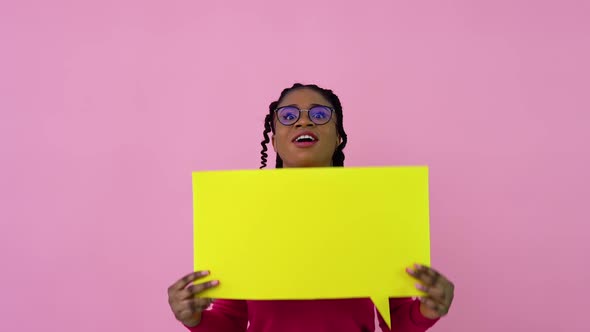 Young African American Girl Stands with Posters for Expression on a Solid Pink Background