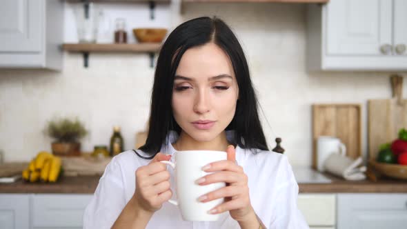 Portrait Of Pensive Woman Holding Cup Of Coffee In The Morning At Home.