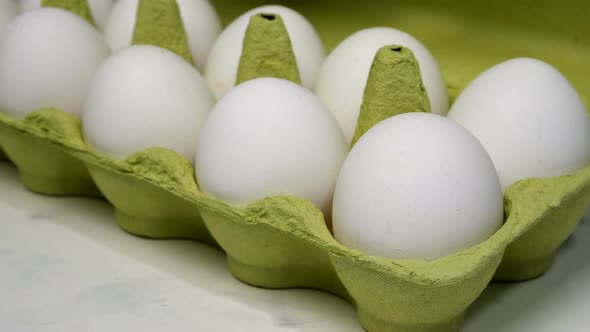 Chefs Hand in Rubber Protective Gloves Take Two White Chicken Eggs From Cardboard Eggs.