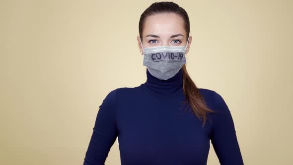 Young Woman in Protective Medical Mask Looking at Camera, Isolated. Covid-19