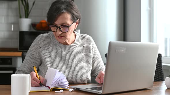 Senior Woman Using Laptop at Home Working Remotely