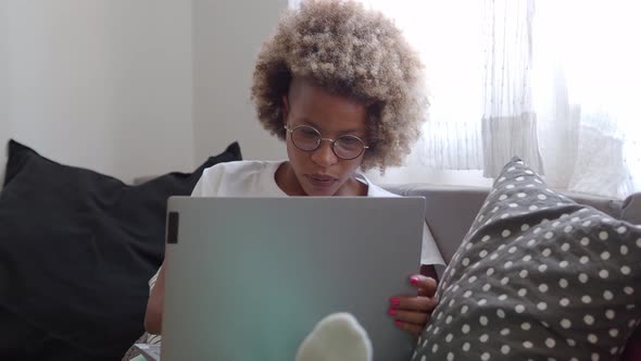 Detail of an African American Woman on the Sofa with a Laptop