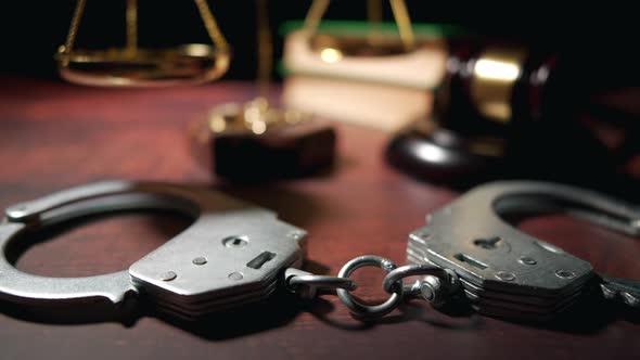 Close Up of a Judge Gavel with Handcuffs and a Scales of Justice