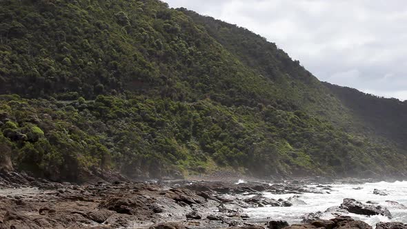 Torturous rocky beach landscape with white crashing waves slamming the coastline.