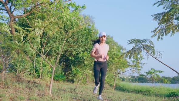 Asian young beautiful sport woman exercise by running workout on street in public park.