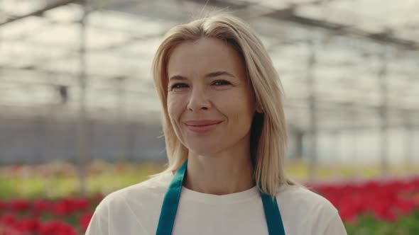 Portrait of the Female Gardener Looking and Smiling at the Camera with Blurred Background