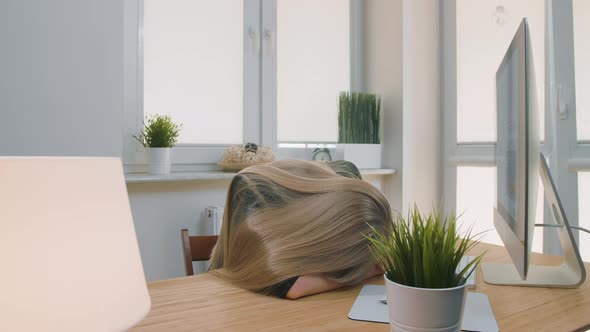 Tired Woman Waking Up at Workplace. Tired Blond Female Office Worker in Elegant Suit Relaxing Lying