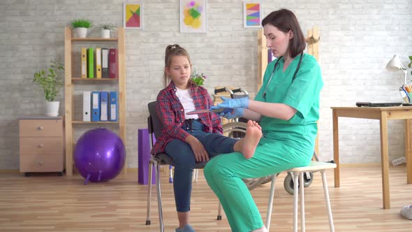 Physiotherapist Tells a Teenage Girl with Orthopedic Problems About Orthopedic Insoles for Flatfoot