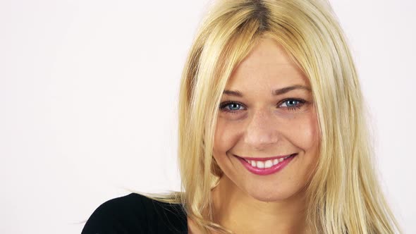 A Young Attractive Woman Smiles and Winks at the Camera - Face Closeup - White Screen Studio