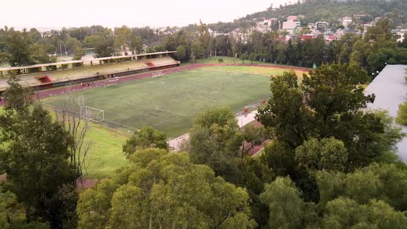 Drone image of people exercising on a competition track in a stadium in the morning