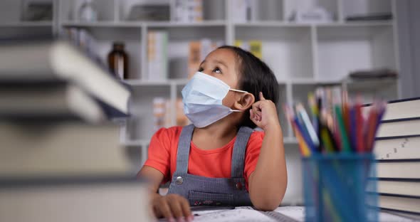 Little girl in medical mask looking up at the ceiling and thinking.