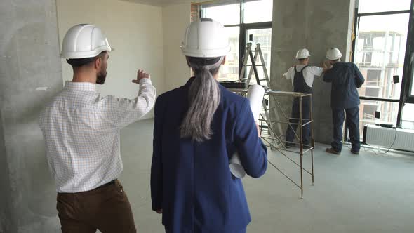 Two Architects Working on Plan of Apartment Layout