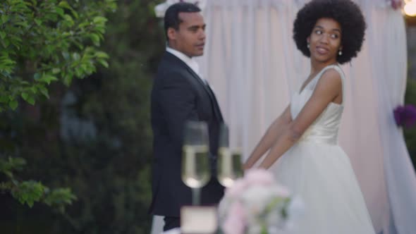 Rack Focus From Happy African American Newlyweds Holding Hands Standing at Altar to Elegant Table