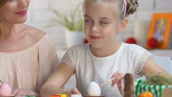 Cute Daughter Kissing Mother on Cheek Decorating Easter Eggs, Preparing for Fest