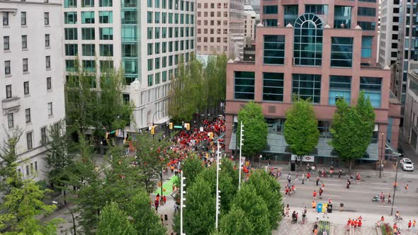 Protesters Walk in a Busy Downtown Urban Area, Drone View from Above in UHD