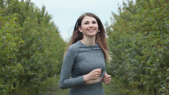 Front Follow Up Shot of Girl Athlete Running Alone Down Getting Ready for a Race