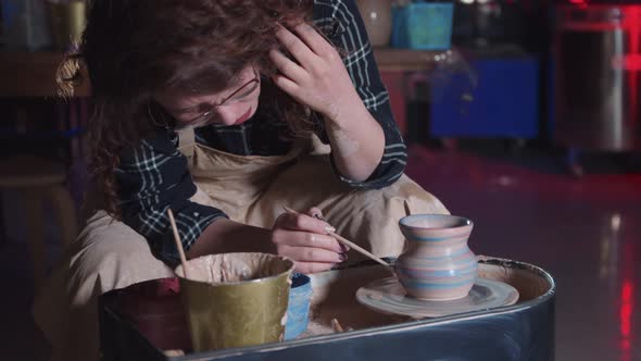 Pottery Crafting  Woman with Curly Hair Applying Colors on the Wet Fresh New Pot