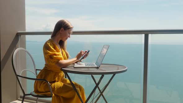 Successful Young Business Woman Working with Laptop Computer and Smartphone